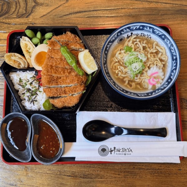 A Hinodeya Ramen bento box with tonkatsu, rice, edamame, egg, and a side of ramen.