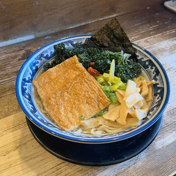 HINODEYA Ramen bowl with a large piece of fried tofu, kale, bamboo shoots, and nori.